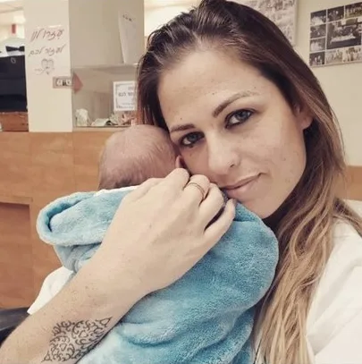 עידית מחזיקה תינוק